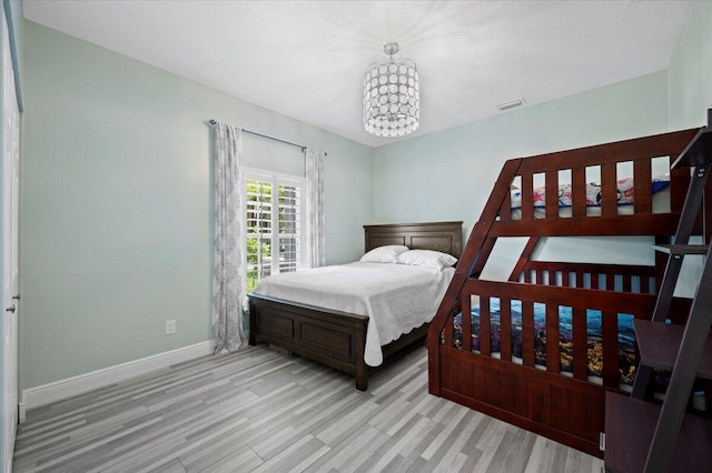 bedroom featuring a chandelier and light hardwood / wood-style floors