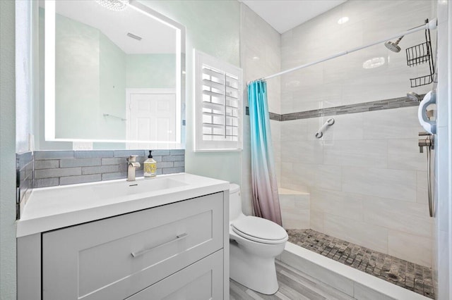 bathroom featuring curtained shower, tasteful backsplash, toilet, and large vanity