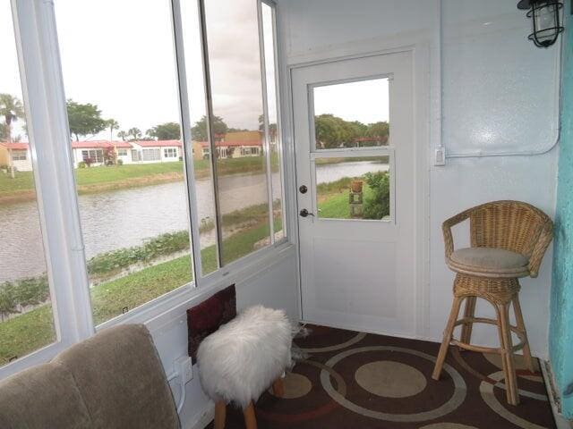 sunroom featuring a water view