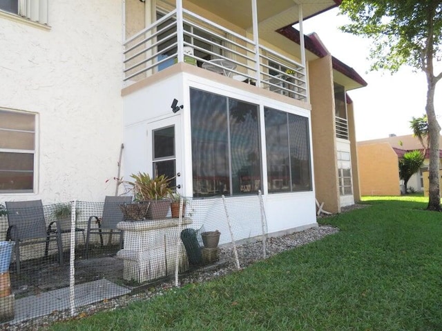 view of property exterior featuring a yard and a balcony