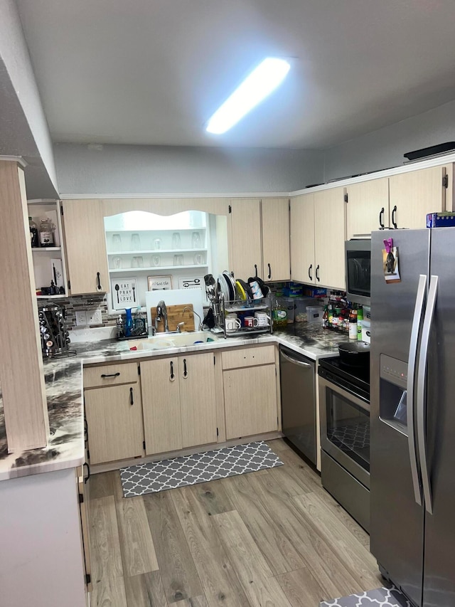 kitchen with light brown cabinetry, sink, light wood-type flooring, and appliances with stainless steel finishes