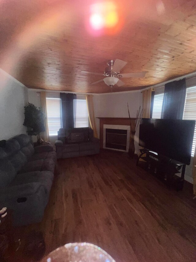 unfurnished living room featuring dark wood-type flooring, ceiling fan, and wood ceiling