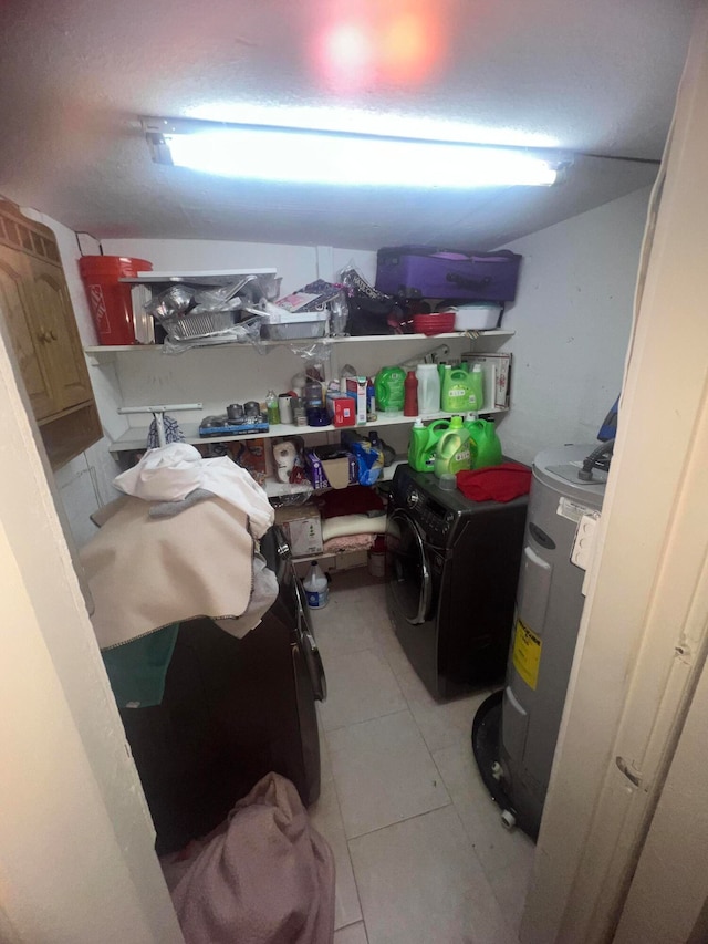 storage room with water heater and washing machine and clothes dryer