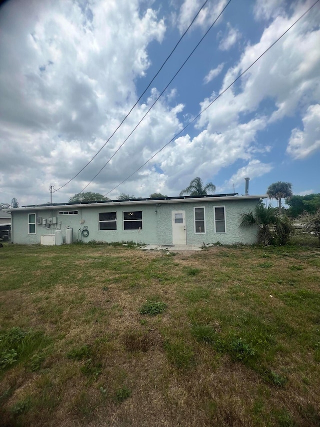 back of property featuring a lawn