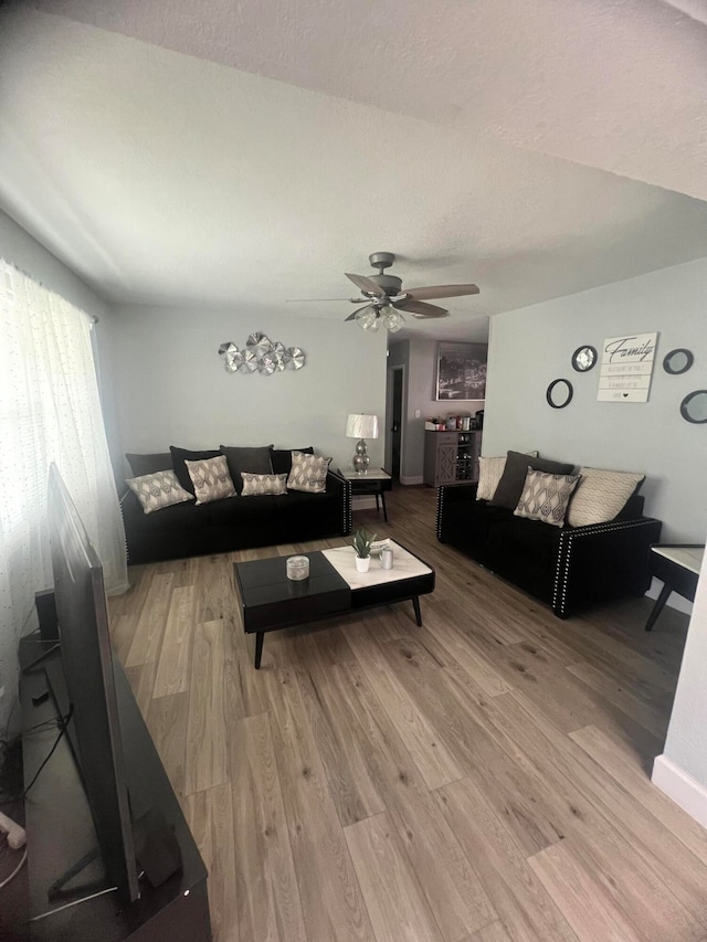 living room featuring hardwood / wood-style floors and ceiling fan