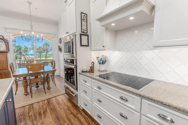 kitchen featuring hanging light fixtures, dark hardwood / wood-style floors, appliances with stainless steel finishes, white cabinetry, and a chandelier