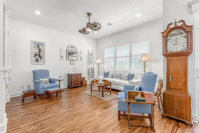 living room with light hardwood / wood-style flooring and crown molding