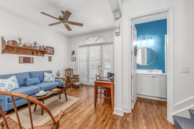 living room featuring light hardwood / wood-style floors, ceiling fan, and ornamental molding