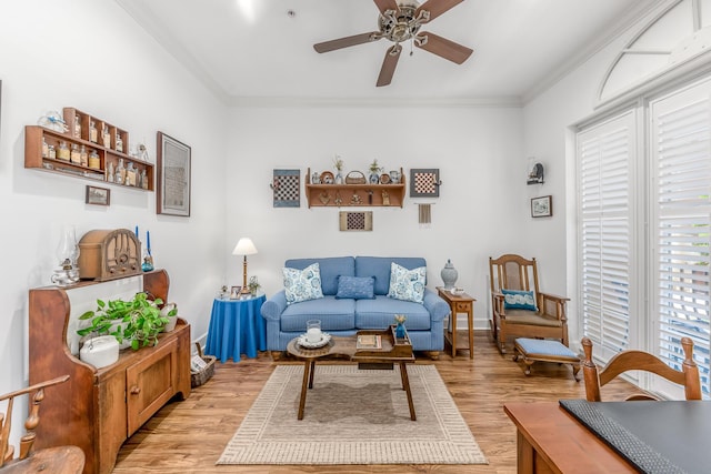 sitting room featuring light wood-type flooring, ceiling fan, and crown molding