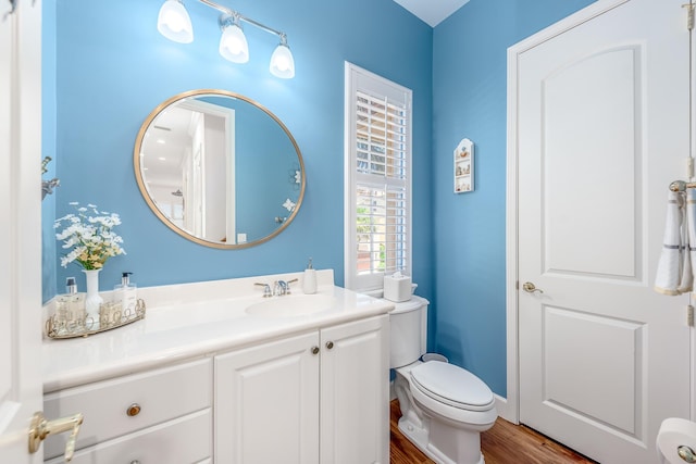 bathroom with hardwood / wood-style floors, vanity, and toilet