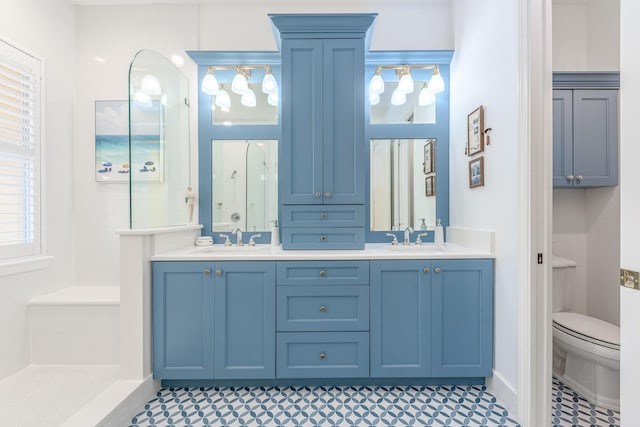 bathroom featuring tile patterned flooring, vanity, toilet, and walk in shower