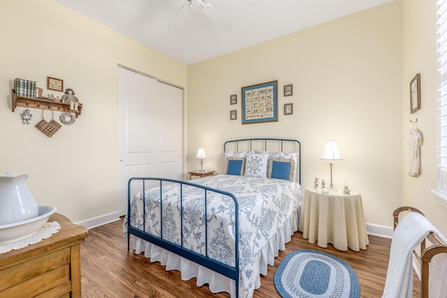 bedroom with ceiling fan, wood-type flooring, and a closet