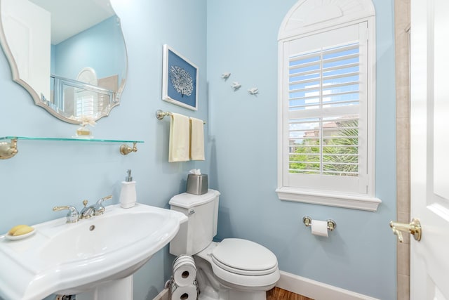 bathroom featuring toilet, sink, and walk in shower