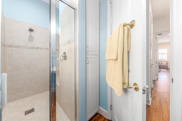 bathroom with hardwood / wood-style floors and a shower with door