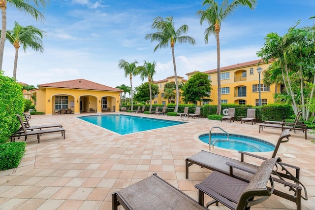 view of pool with a patio area and a hot tub