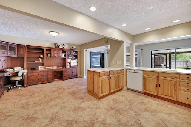 kitchen featuring hanging light fixtures, kitchen peninsula, white dishwasher, sink, and a textured ceiling