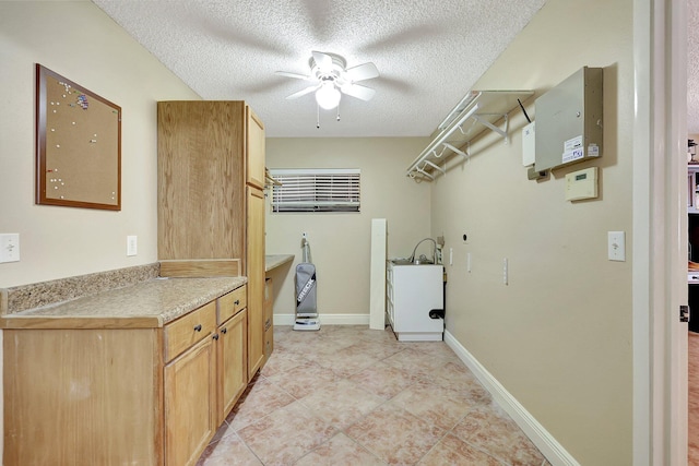 laundry room with electric dryer hookup, a textured ceiling, and ceiling fan