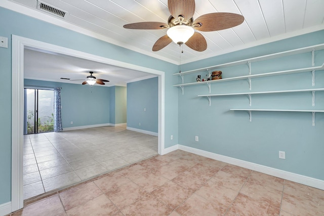 tiled empty room featuring ceiling fan and ornamental molding