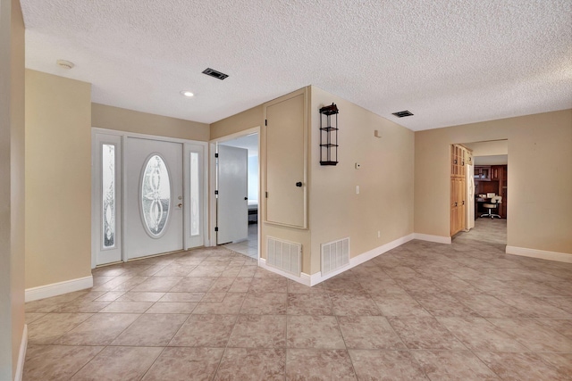 tiled foyer featuring a textured ceiling