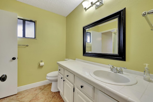 bathroom featuring vanity, a textured ceiling, toilet, and tile patterned flooring