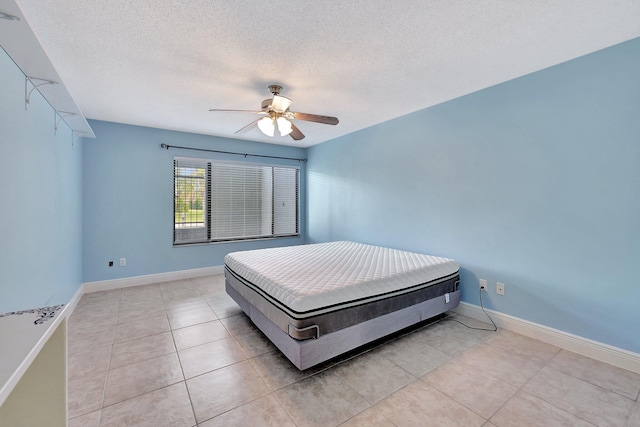 tiled bedroom with ceiling fan and a textured ceiling