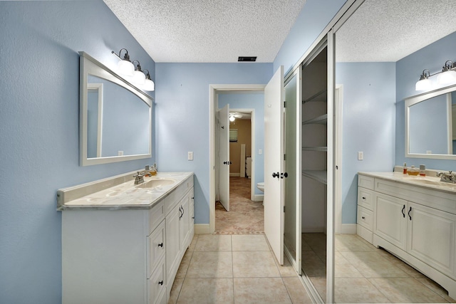 bathroom with vanity, a textured ceiling, tile patterned floors, and ceiling fan