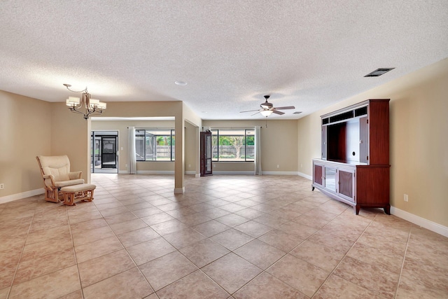 unfurnished living room with a textured ceiling, ceiling fan with notable chandelier, and light tile patterned floors