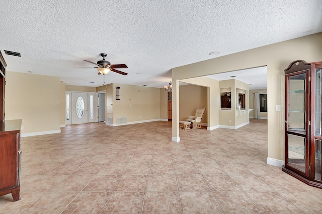 unfurnished living room with ceiling fan, a textured ceiling, and light tile patterned floors