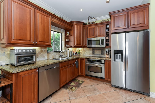 kitchen featuring backsplash, crown molding, sink, appliances with stainless steel finishes, and light stone counters