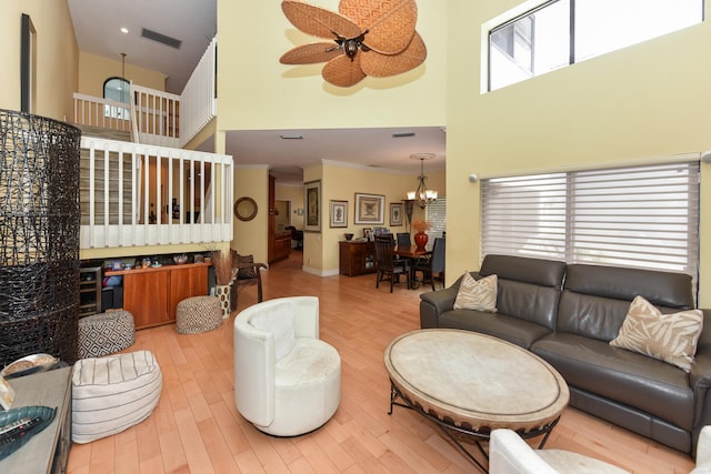 living room with hardwood / wood-style floors, a towering ceiling, and a healthy amount of sunlight