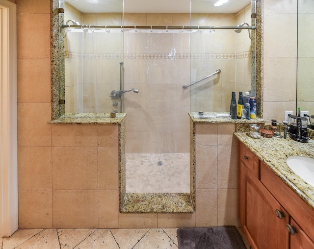 bathroom with a shower with curtain, vanity, and tile walls