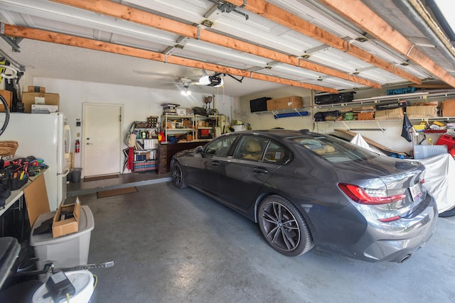 garage with ceiling fan, a garage door opener, and white refrigerator