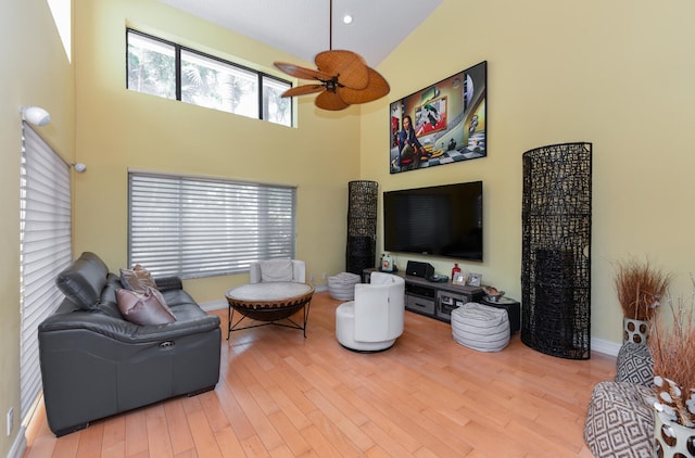 living room featuring ceiling fan, high vaulted ceiling, and hardwood / wood-style flooring