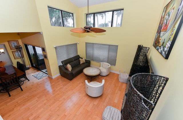 living room featuring ceiling fan, high vaulted ceiling, and hardwood / wood-style flooring