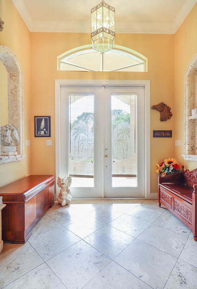 entryway with french doors, light tile patterned floors, and ornamental molding