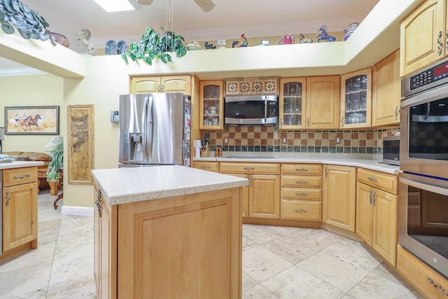 kitchen featuring backsplash, stainless steel appliances, ceiling fan, light tile patterned floors, and a kitchen island