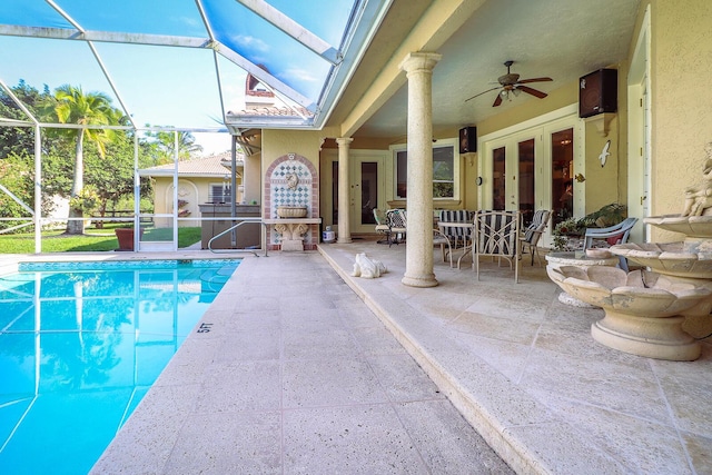 view of swimming pool with a lanai, a patio area, ceiling fan, and french doors