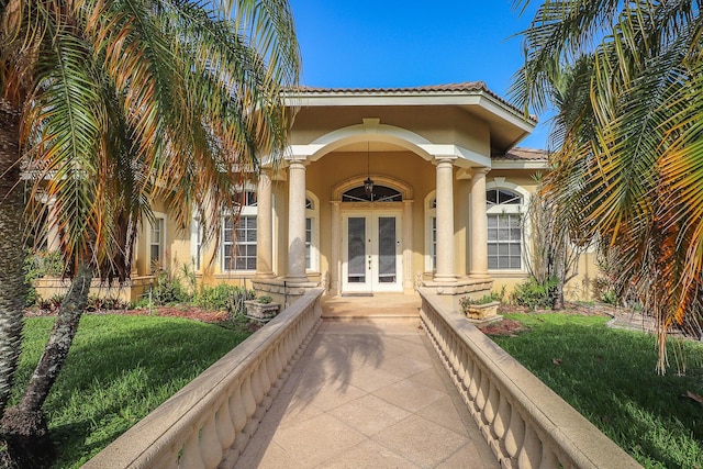 property entrance with french doors and a lawn