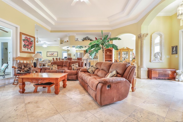 living room with decorative columns, a raised ceiling, ceiling fan, and ornamental molding