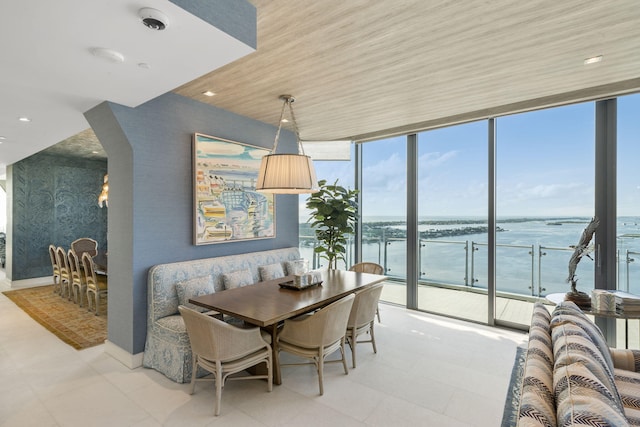 dining area featuring a water view, floor to ceiling windows, and wood ceiling