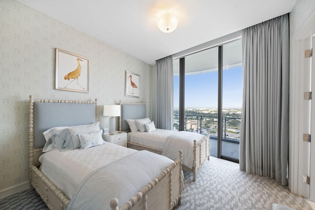 bedroom featuring light carpet, access to outside, and a wall of windows