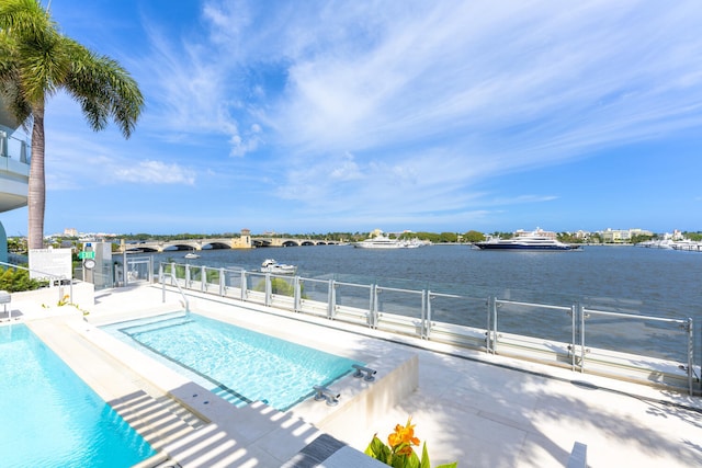 view of swimming pool featuring a patio area and a water view