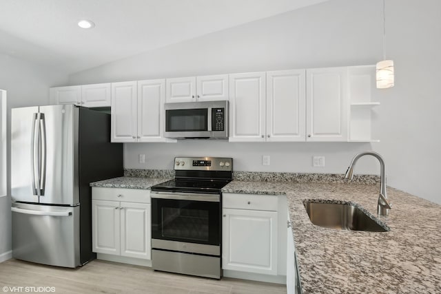 kitchen featuring white cabinets, stainless steel appliances, lofted ceiling, and sink