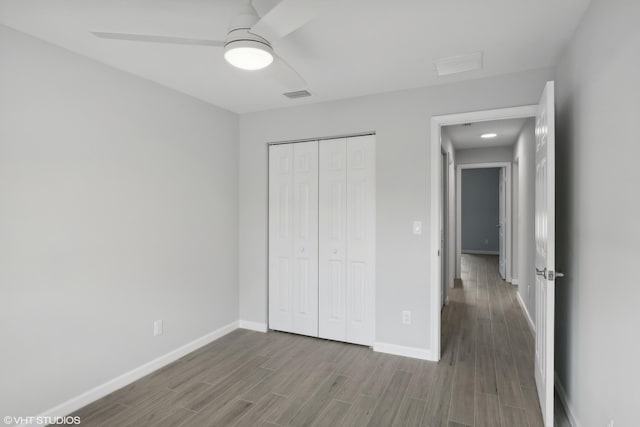 unfurnished bedroom with ceiling fan, a closet, and hardwood / wood-style floors