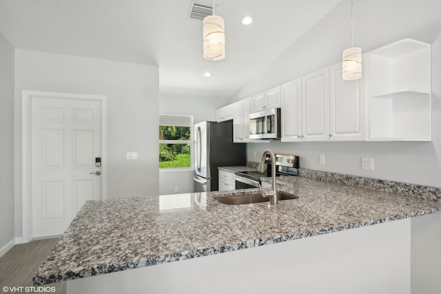 kitchen featuring sink, hanging light fixtures, stainless steel appliances, kitchen peninsula, and lofted ceiling