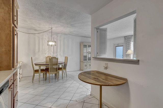 tiled dining room with a textured ceiling and a chandelier