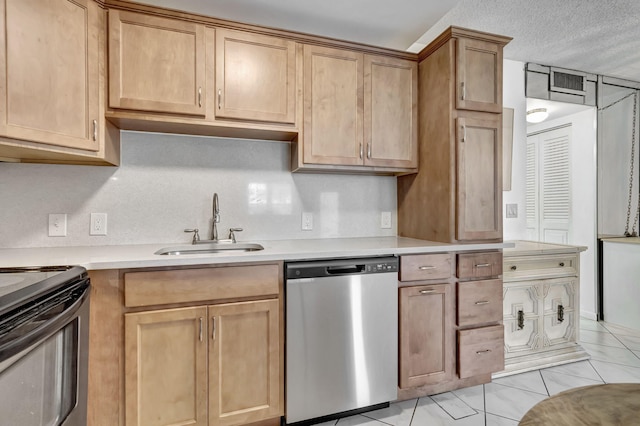 kitchen featuring light tile patterned flooring, a textured ceiling, stainless steel appliances, and sink