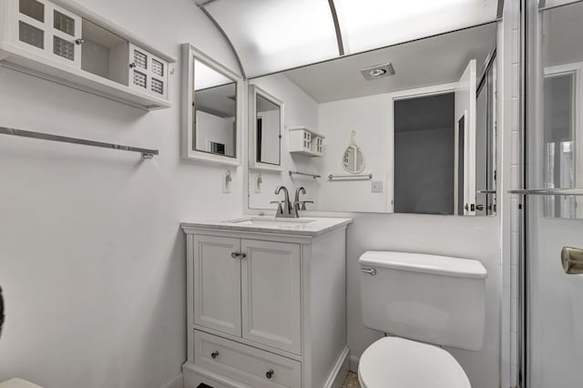 bathroom featuring vanity, toilet, and a shower with shower door