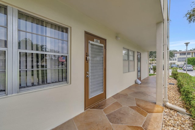 view of exterior entry featuring covered porch