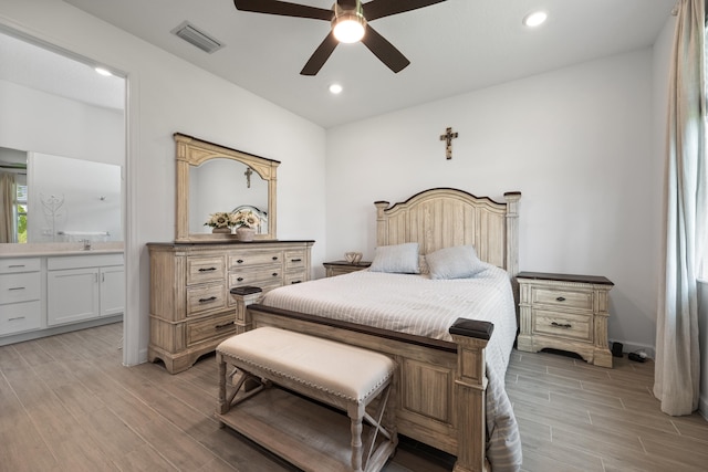 bedroom with ceiling fan, sink, and ensuite bath